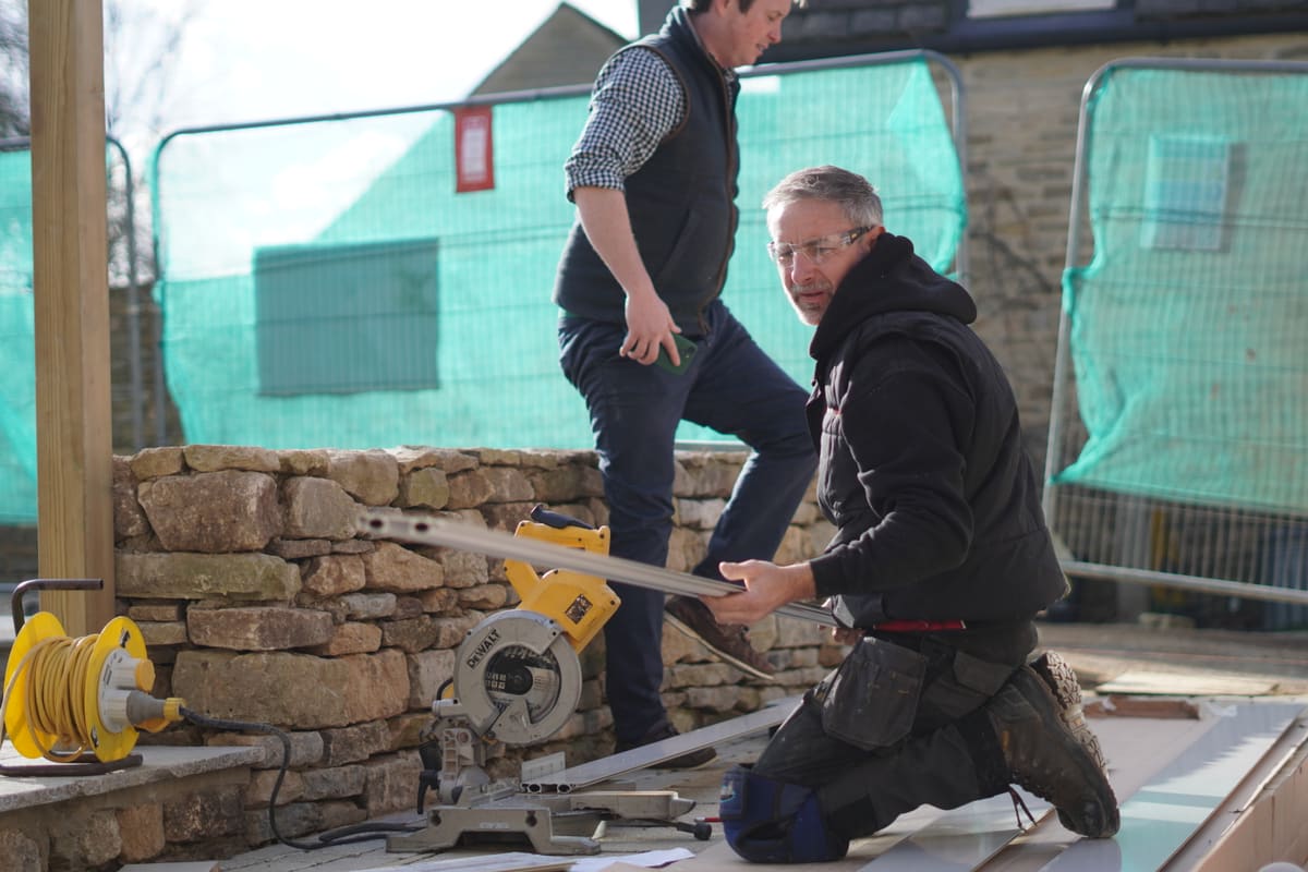 Installers fitting ThermaSkirt skirting heating during a heat pump project