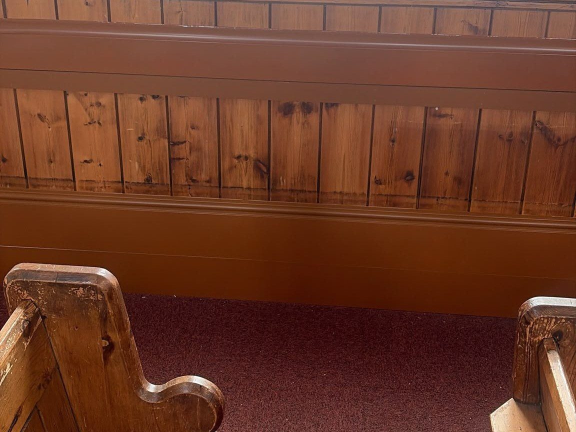 ThermaSkirt-e heating runs along the panelled nave wall between two wooden pews