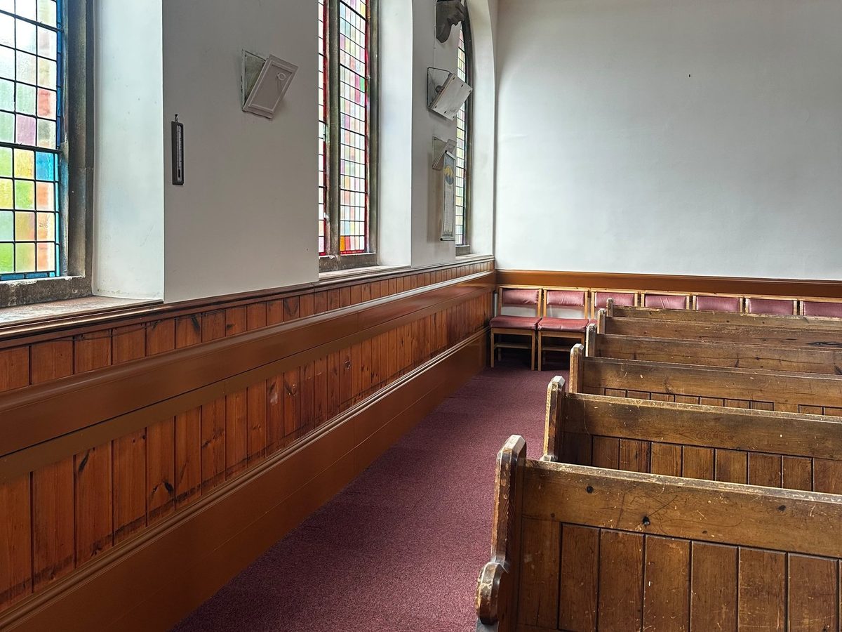 Heated skirting and mid-panel tiers running along the nave wall towards the rear seating