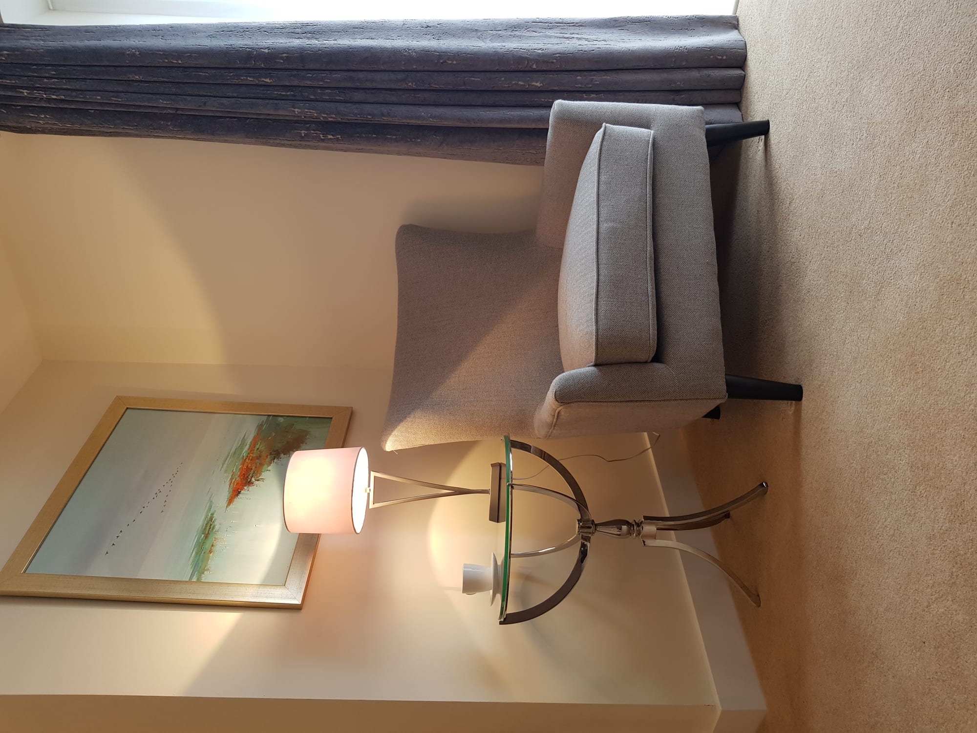 A happy homeowner sitting comfortably in their newly heated ThermaSkirt living room