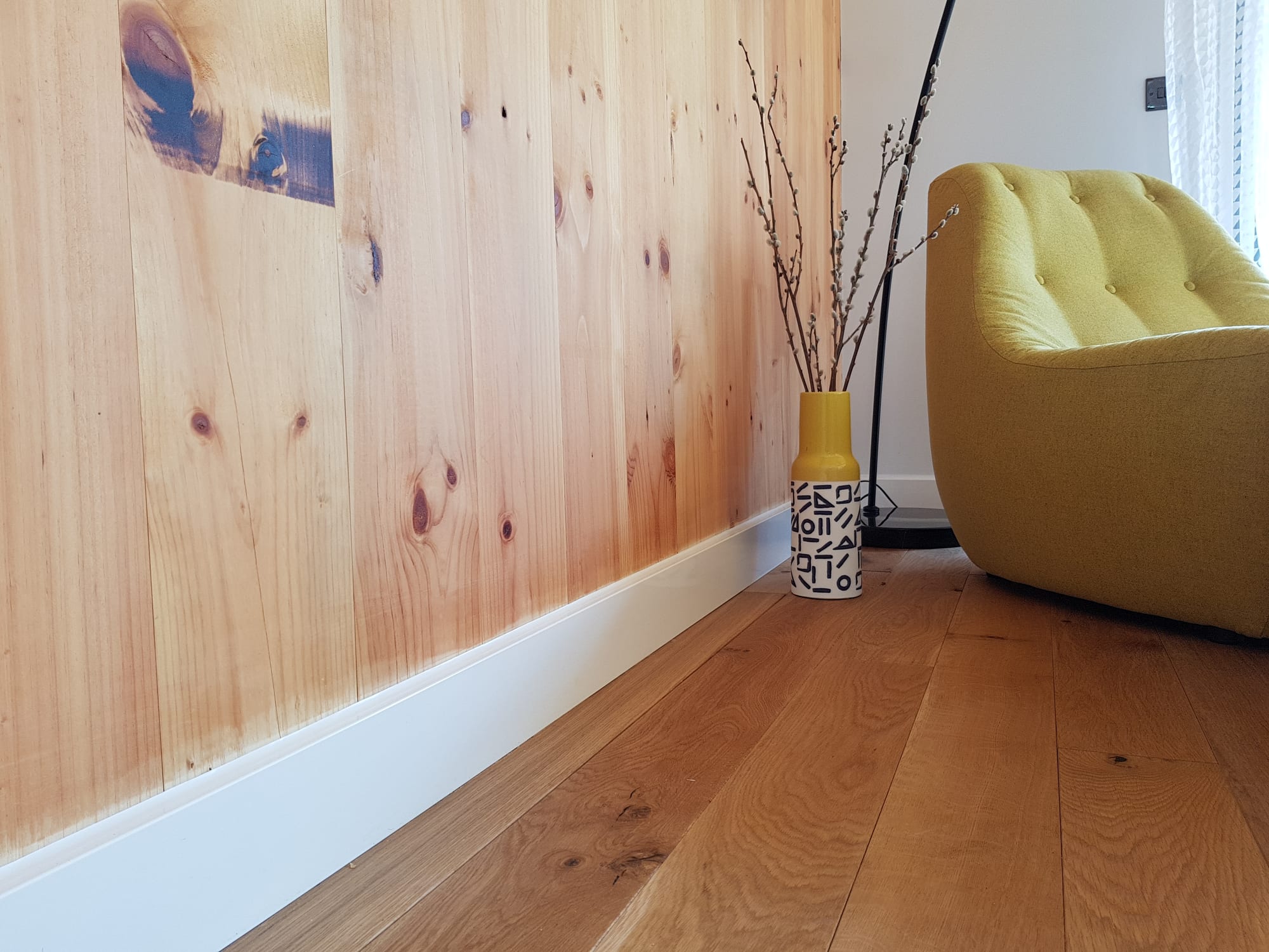 ThermaSkirt skirting installed along a wall, showing the slim white aluminium profile.