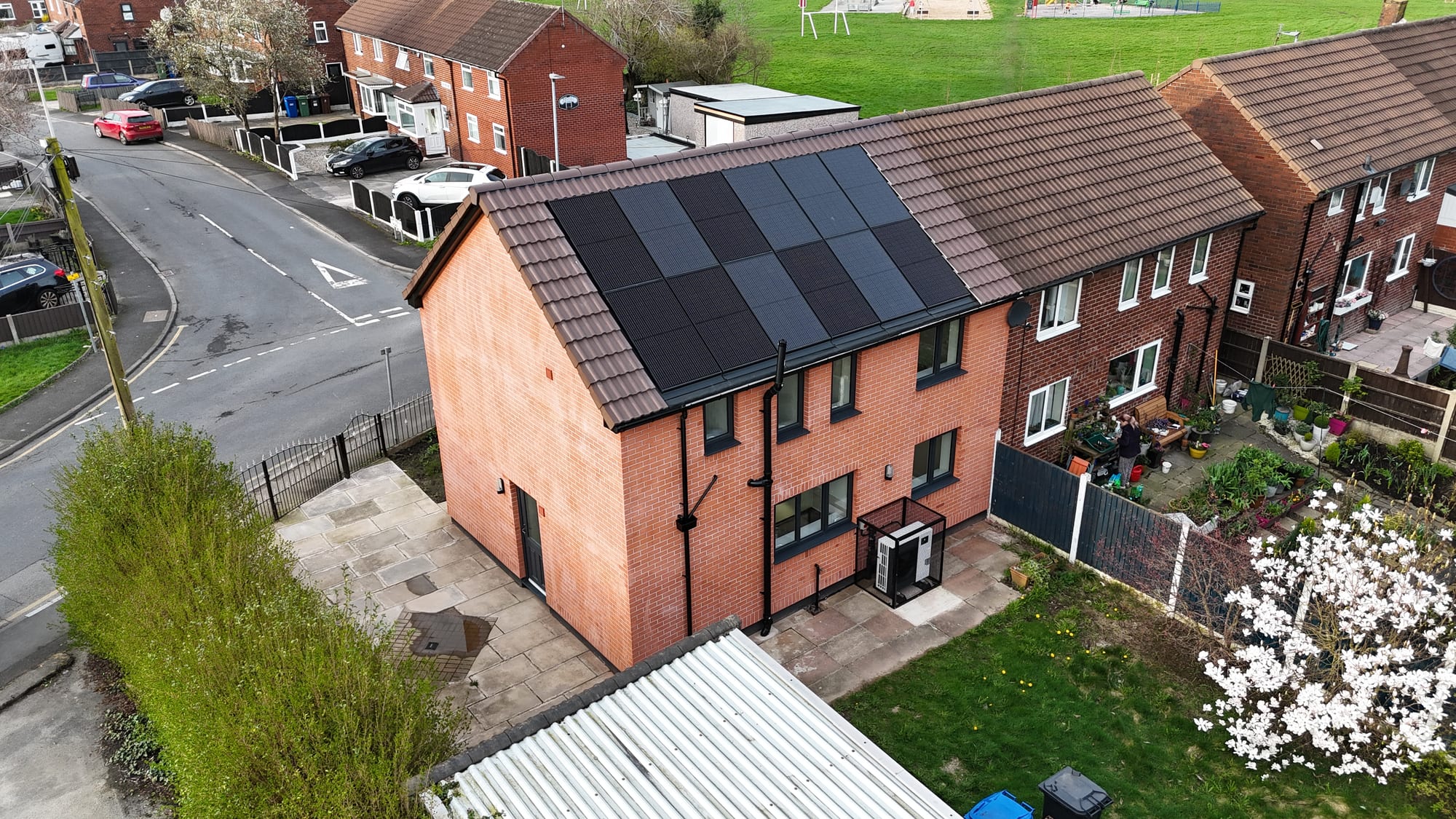 A brick home retrofitted with roof solar panels and an air-source heat pump
