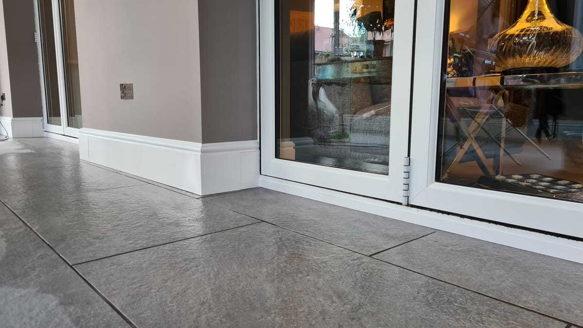 ThermaSkirt Deco BM3 in an extension with patio doors, showing external corner detail on tiled floor