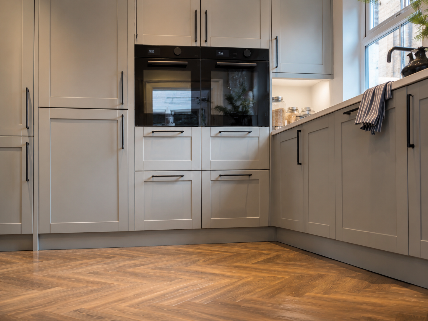 Grey-blue kitchen plinth profile blending into the run of base units