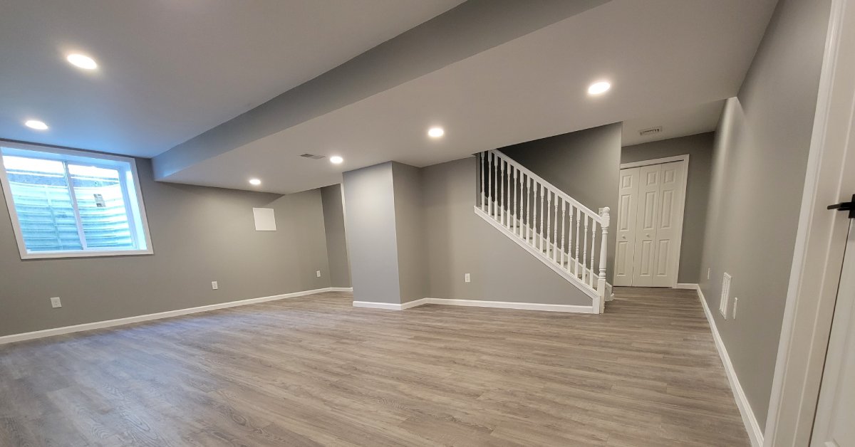Modern finished basement with neutral grey walls and oak-effect flooring
